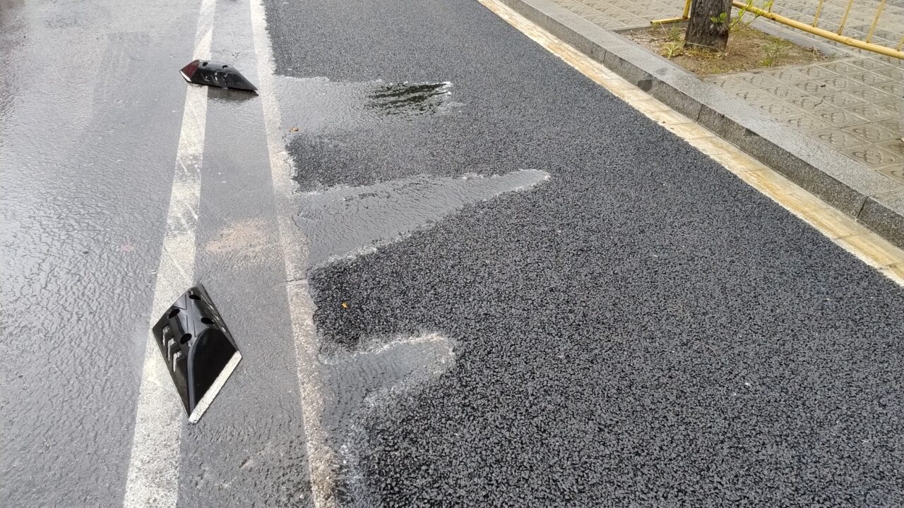 The newly laid permeable pavement in a bike lane, efficiently managing rainfall just one day after installation. Despite rainfall, there are no visible signs of water pooling, which is crucial for both safety and flood prevention.